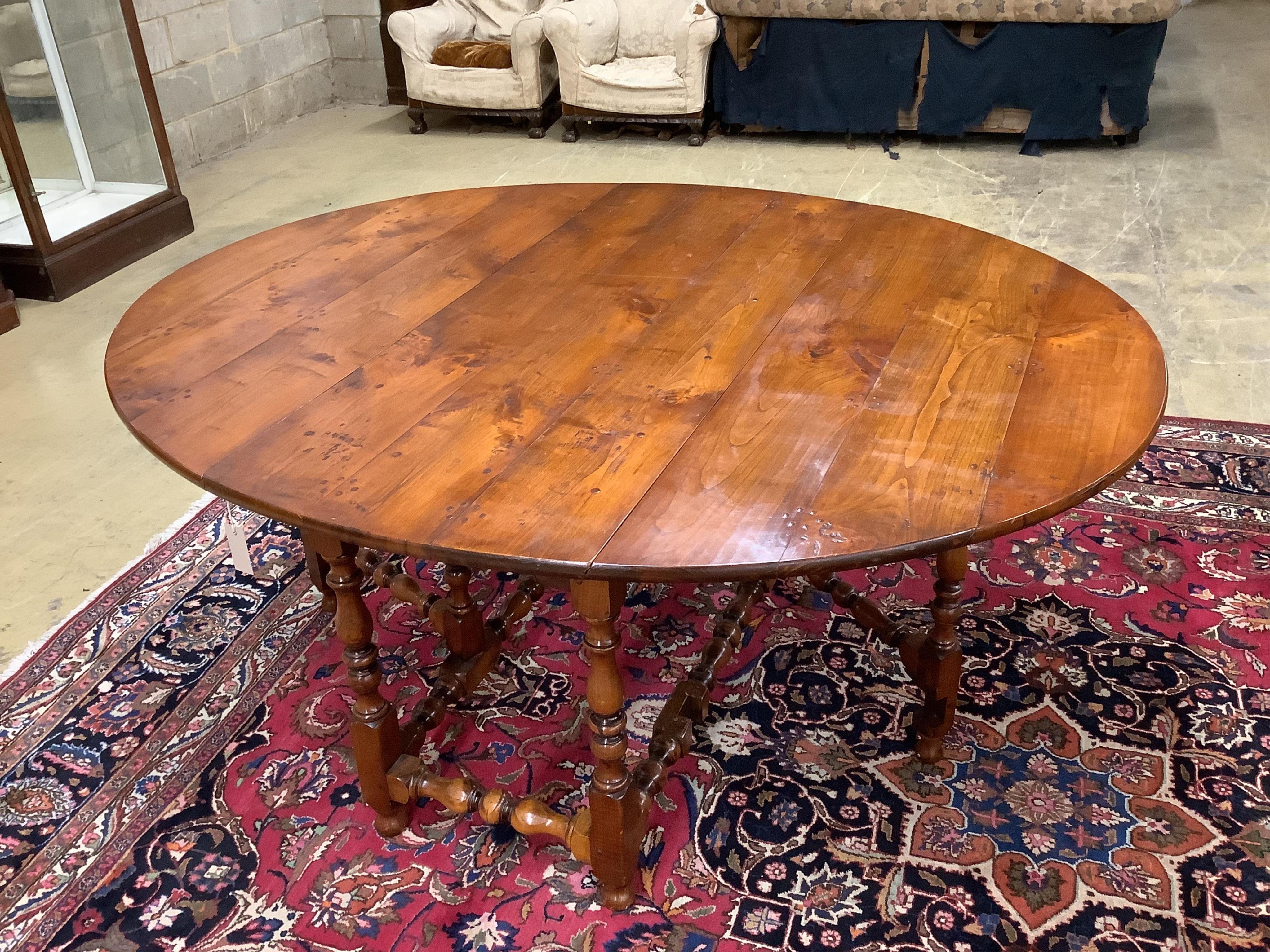 A reproduction 18th century style elm gateleg dining table on turned baluster under frame, width 169cm extended, depth 142cm, height 75cm. Condition - good with a rich colour.